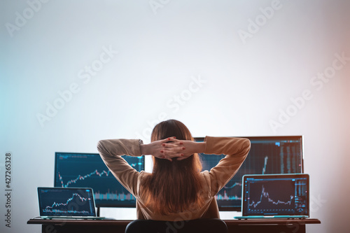 Canvas Print back view of female crypto trader resting and looking at monitor stock exchange
