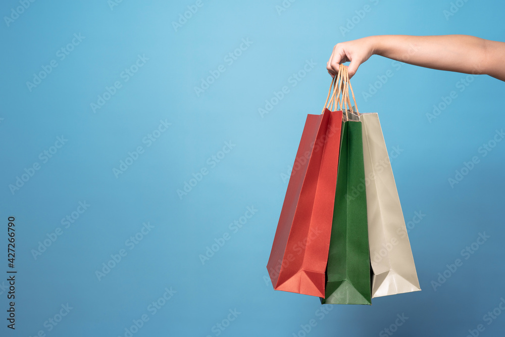 Women holding shopping bags, Isolated on blue background.
