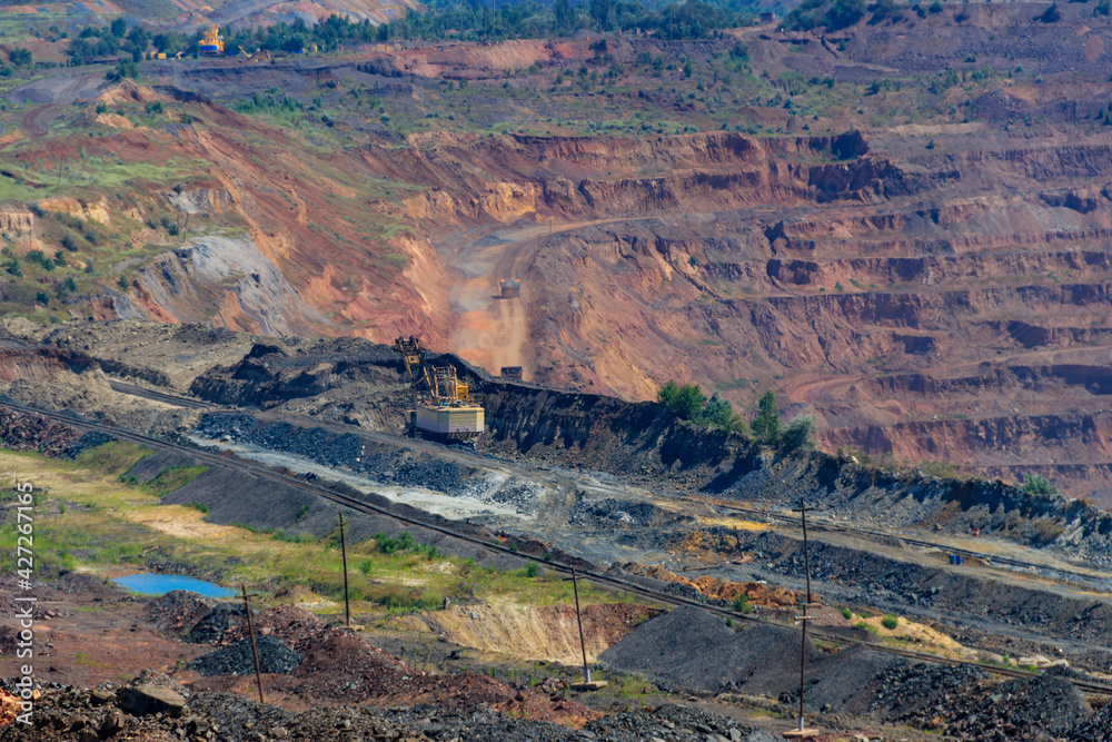 Huge iron ore quarry with working dump trucks and excavators in Kryvyi Rih, Ukraine