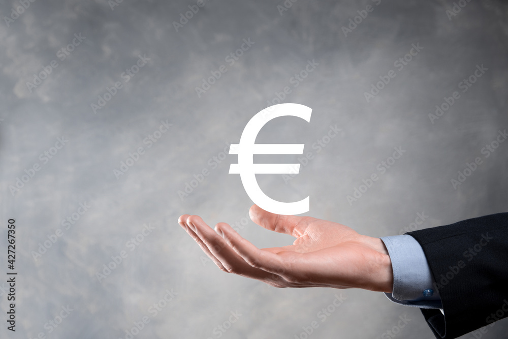 Businessman holds money coin icons EUR or Euro on dark tone background..Growing money concept for business investment and finance Businessman holds money coin icons EUR or Euro on dark tone background..Growing money concept for business investment and finance