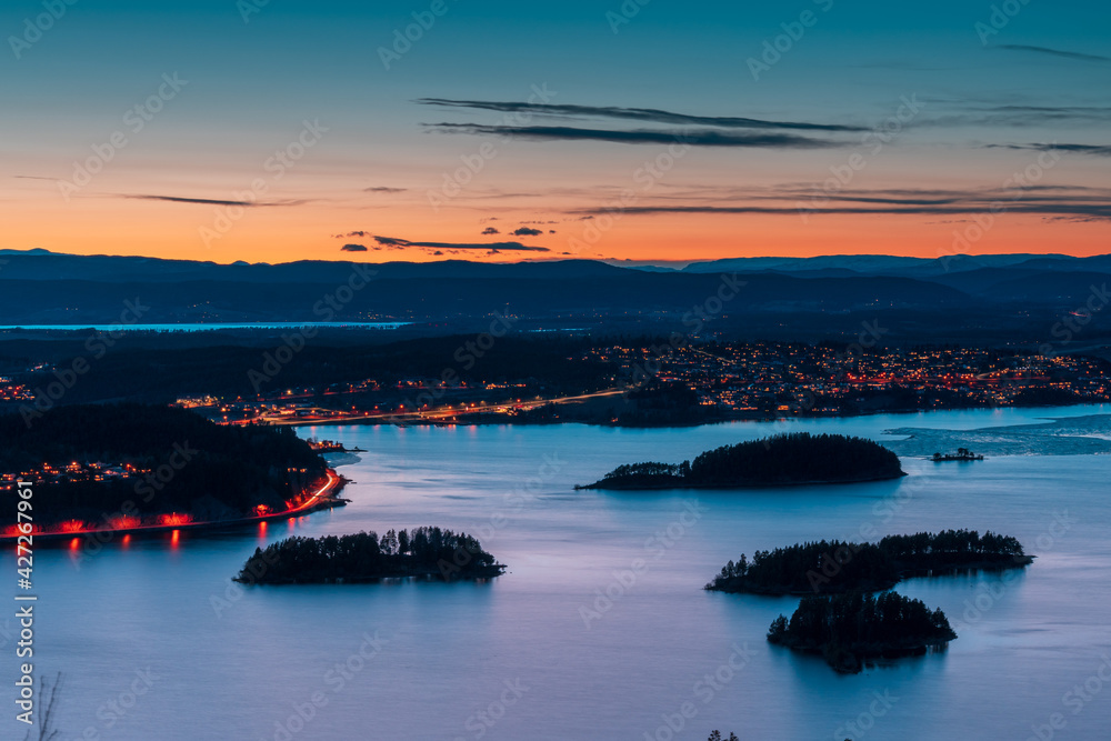 Sunset over Steinsfjorden, a branch of Lake Tyrifjorden located in Buskerud, Norway. View from Kongens Utsikt (Royal View) at Krokkleiva Sunset over Steinsfjorden, a branch of Lake Tyrifjorden located in Buskerud, Norway. View from Kongens Utsikt (Royal View) at Krokkleiva