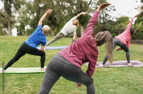 Multiracial people doing yoga at park with social distance for coronavirus outbreak photo