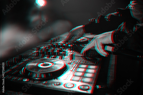 DJ console for mixing music with hands and with blurred people at a night club. Black and white with 3D glitch virtual reality effect