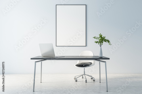 Fototapeta Naklejka Na Ścianę i Meble -  Blank white poster in black frame on light wall behind stylish work space with marble table, modern laptop and concrete floor, 3D rendering, mock up