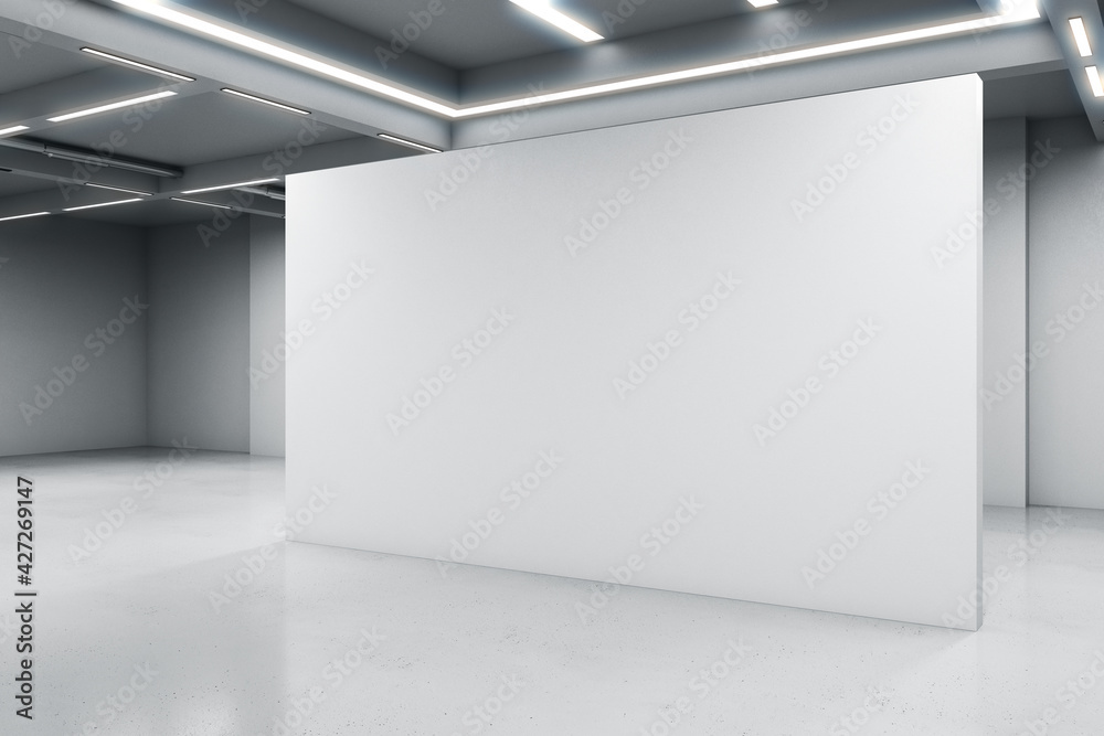 Fototapeta premium Empty big white room with a white blank concrete wall in the middle, artificially lighted, showroom and exhibition interior design concept, 3d rendering, mock up