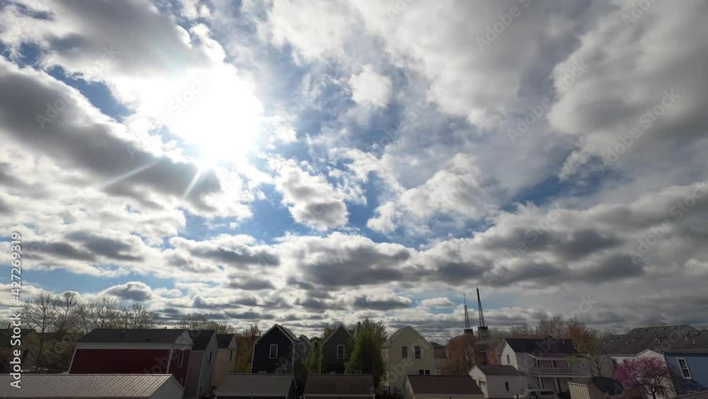 Beautiful spring sun and clouds timelapse over a small town. Beautiful spring sun and clouds timelapse over a small town.