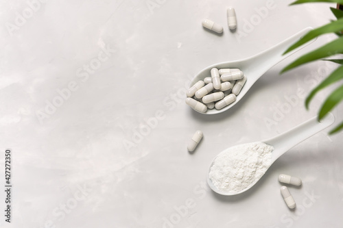 Collagen powder and pills on a gray background with a copy space. Natural beauty and health supplement