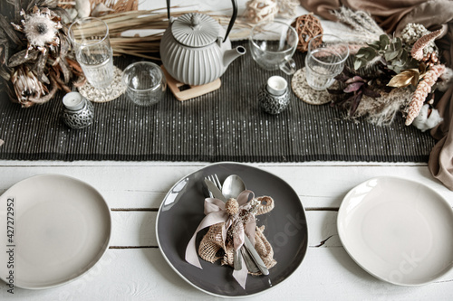 Festive table setting design with many hygge-style decor details.