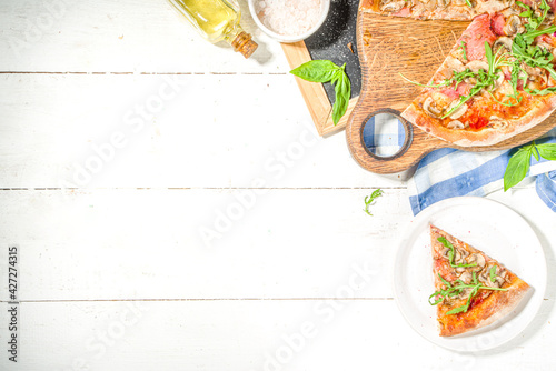 Tasty Italian traditional pizza with ham and mushrooms, on white wooden background. Mediterranean food recipe concept, top view