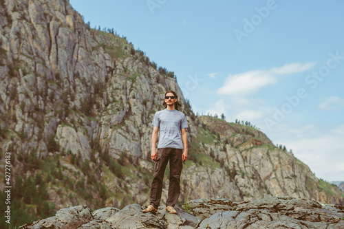 the guy stands on the background of the mountains
