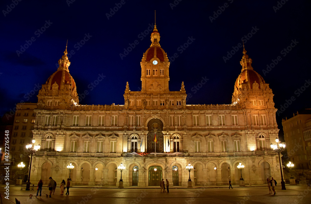 Fotografía nocturna de un edificio histórico muy bien iluminado en la ciudad de La Coruña, España