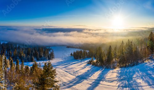 Magical winter panorama of beautiful snowy slopes at a ski resort in Europe on a sunny, windless frosty day. The concept of active recreation in winter. Copyspace © YouraPechkin