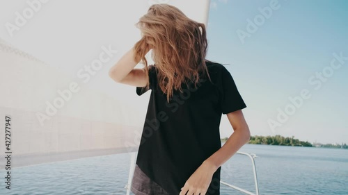 a slender girl on a yacht in a bikini and a black t-shirt