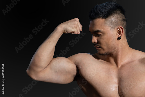 Close Up on Naked Male Bodybuilder Flexing His Biceps Muscle