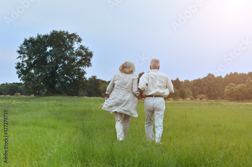 senior couple running on the field