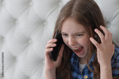 Portrait of Beautiful girl with smartphone at home shouting