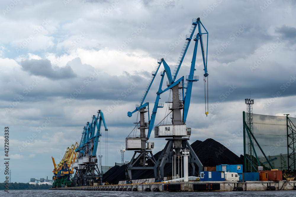 Coal industry. Blue working coal cranes in the industrial port.
