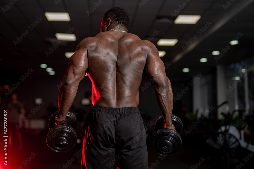 Athlete man doing back exercises. African athlete in the gym.