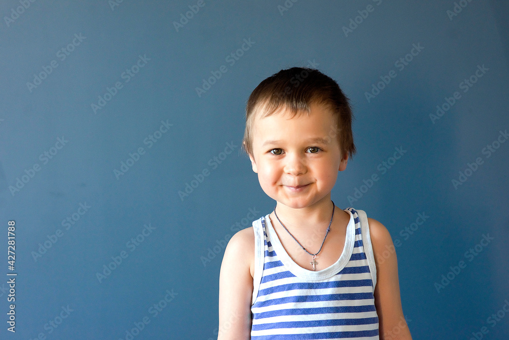 Happy child. Portrait of a beautiful boy in a vest, smiling, isolated on a blue background. selective focus Happy child. Portrait of a beautiful boy in a vest, smiling, isolated on a blue background. selective focus