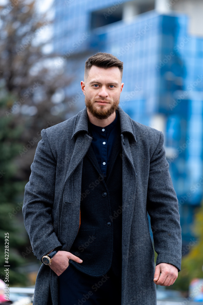 Portrait of handsome young man posing for camera. Stylish male standing on urban street. Portrait of handsome young man posing for camera. Stylish male standing on urban street.