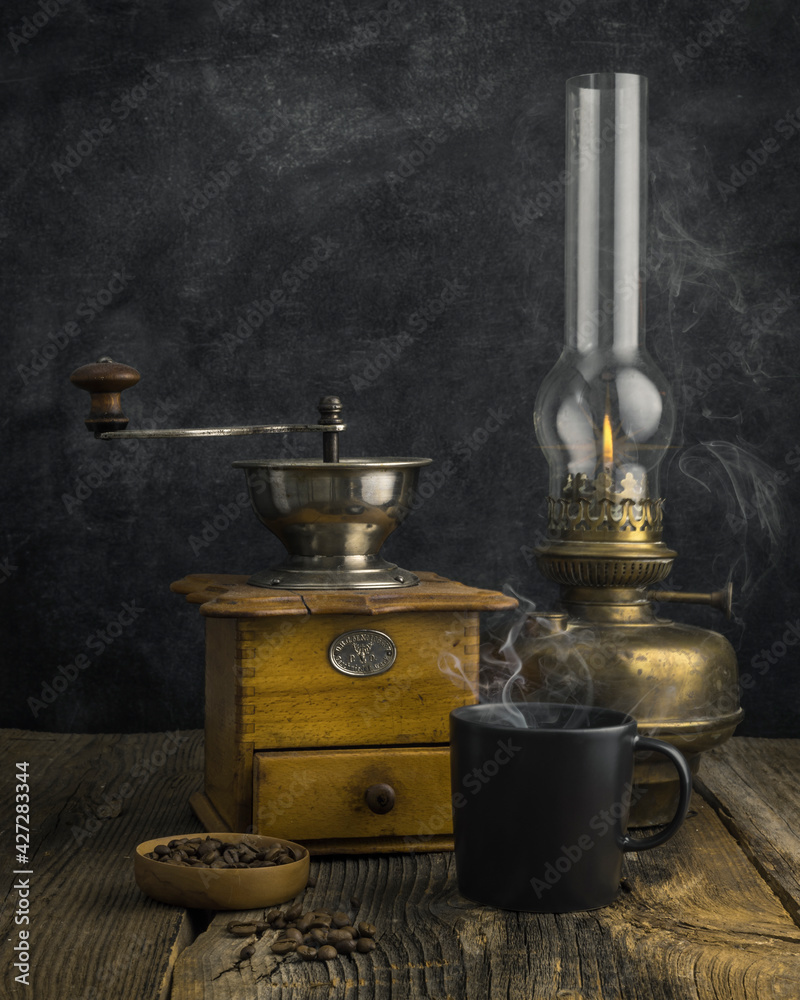 Antique coffee grinder with steaming coffee, and coffee beans Antique coffee grinder with steaming coffee, and coffee beans