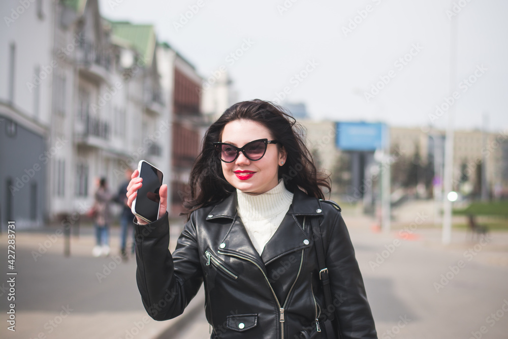 beautiful hipster girl in the spring walks along the street of her city