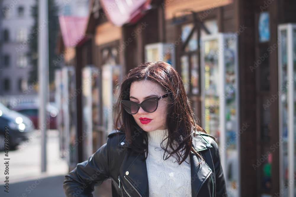 beautiful hipster girl in the spring walks along the street of her city