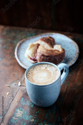 Cappuccino and Croissant on dark wooden background. Close up. 