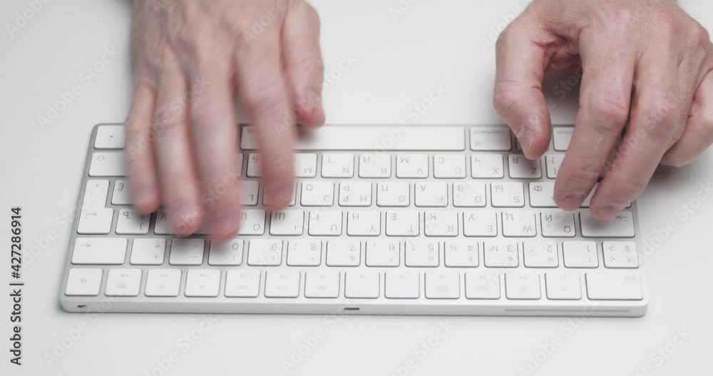 The person is typing on a computer keyboard of white color, close-up view, soft light, bluetooth device, wireless technology The person is typing on a computer keyboard of white color, close-up view, soft light, bluetooth device, wireless technology