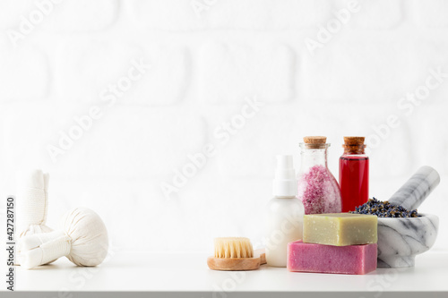 Cosmetics bottles and natural handmade soap on white background