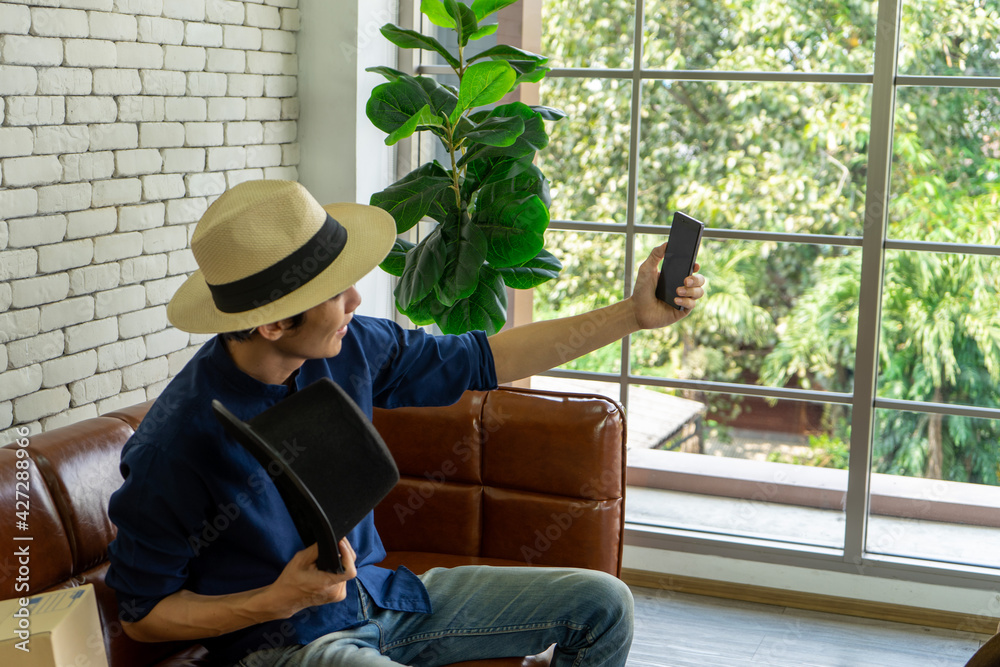 Asian young business man working from home in new normal social distancing reviewing products on record streaming by cellular phone Asian young business man working from home in new normal social distancing reviewing products on record streaming by cellular phone