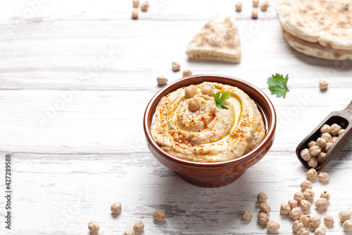 Photos Bowl of homemade hummus on light background with copyspace.