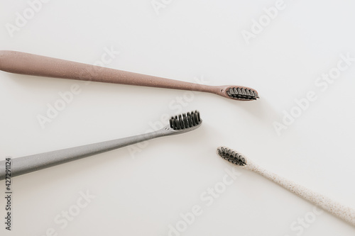 Set of biodegradable natural bamboo eco-friendly toothbrushes on white background. Top view, flat lay. Copy space. Zero waste, Dental care plastic free concept. photo