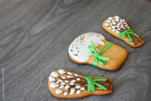 Cookies in the form of Easter cakes, willow branches on a gray wooden surface or table.