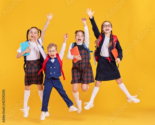 Obraz na plátně Cheerful schoolkids in uniform having fun