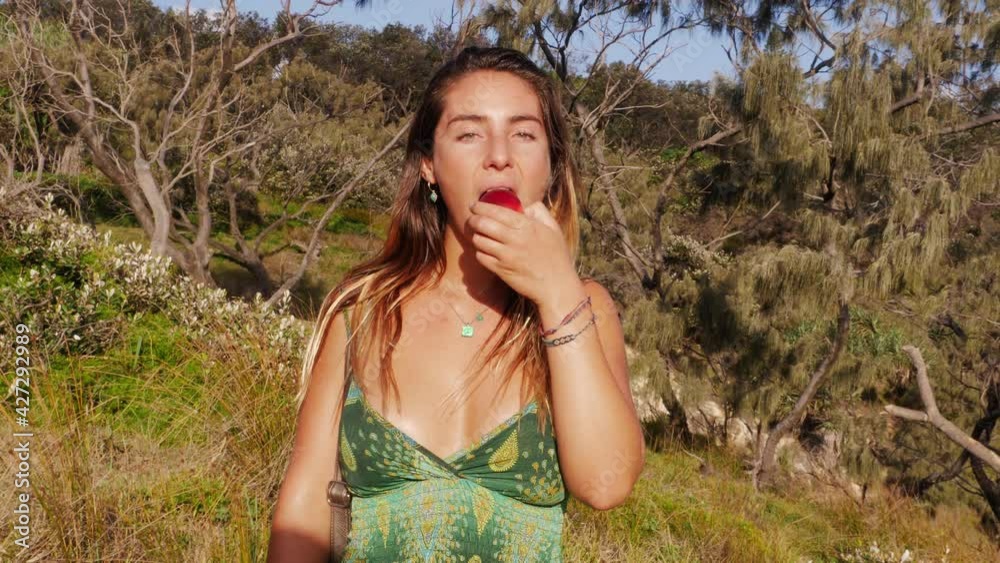 Sexy Caucasian Girl Eating An Apple Under The Sun At Headland Park - Point Lookout, QLD, Australia. - medium shot Sexy Caucasian Girl Eating An Apple Under The Sun At Headland Park - Point Lookout, QLD, Australia. - medium shot