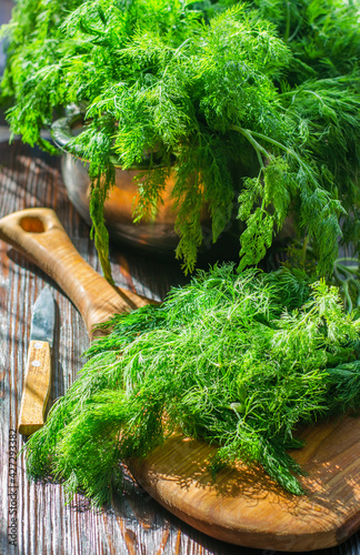 Freshly cut, green, young dill on a kitchen board