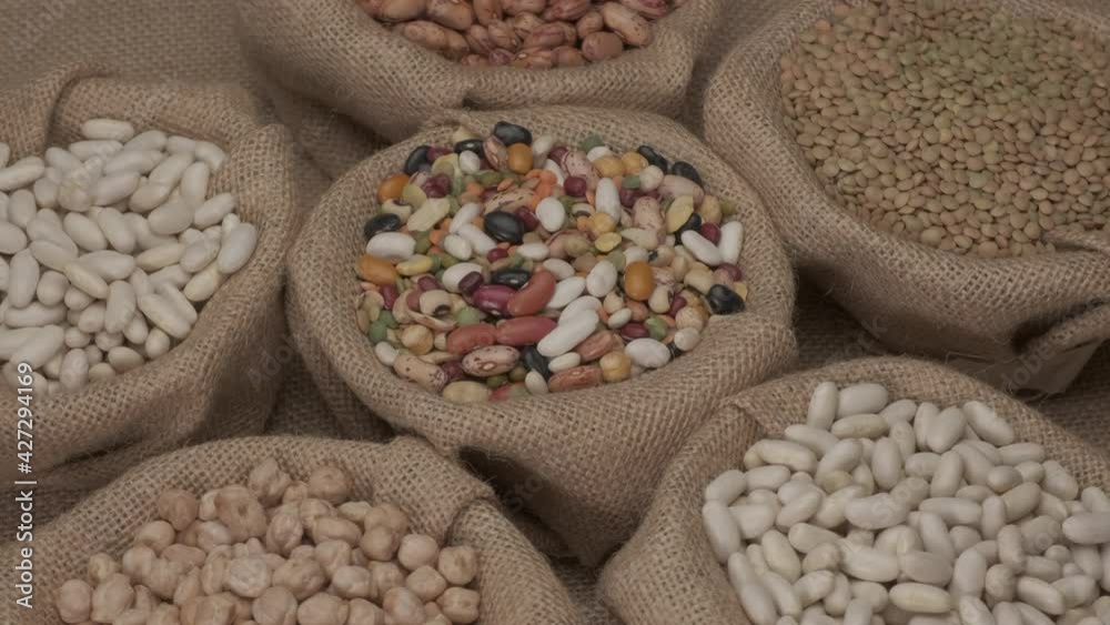 Legumes dry mixed various beans, lentils, chickpeas rotating on jute bowl Legumes dry mixed various beans, lentils, chickpeas rotating on jute bowl