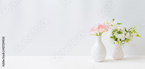 Home interior with decor elements. Pink tulips in a vase on a light background