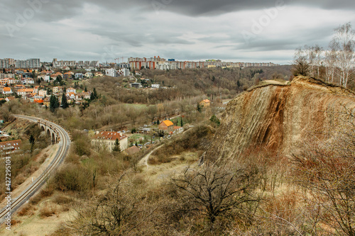 View of Prokopske valley nature reserve, Prague, Czech Republic.Attractive landscape with deep valleys, local streams, dramatic limestone rocks and hiking trails,houses in background.City park scenery photo