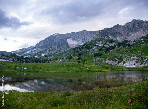 panoramic view of the mountain lake with tourist tents  a cloudy summer day. Adygea  Russia.