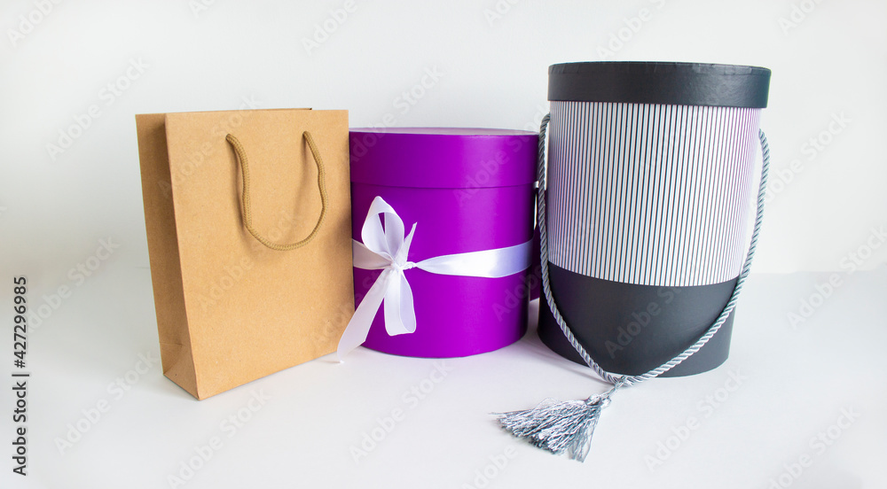 Round gift boxes and disposable bag of kraft paper on a beautiful white background. Copy space. Concept. Web banner. Round gift boxes and disposable bag of kraft paper on a beautiful white background. Copy space. Concept. Web banner.