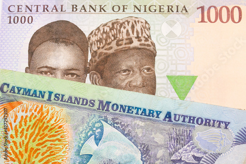 A macro image of a blue, purple and green one thousand  naira note from Nigeria paired up with a colorful one dollar note from the Cayman Islands.  Shot close up in macro. photo