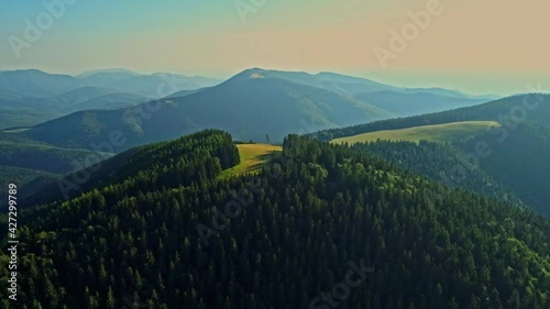 Aerial drone footage view of Carpathian mountains with a beautiful green meadow and hills. Tarcului Mountains, Romania. photo