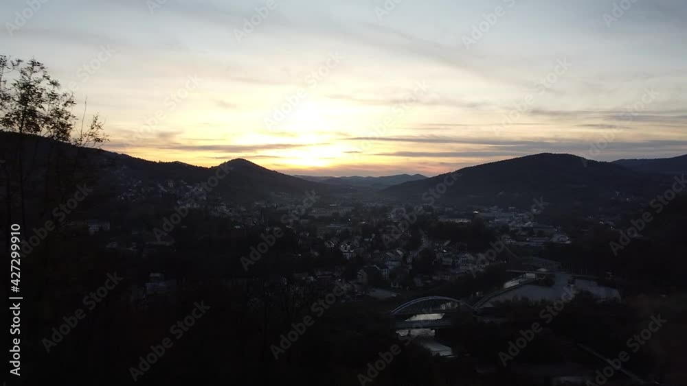 a couple watching a sunset from a viewing point above small city (drone video) a couple watching a sunset from a viewing point above small city (drone video)