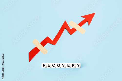 Global economy recovery, Business Economic growth. Financial, industrial and market sector comeback and upturn concept. Paper red arrow graph with medical plaster going upward in blue background photo