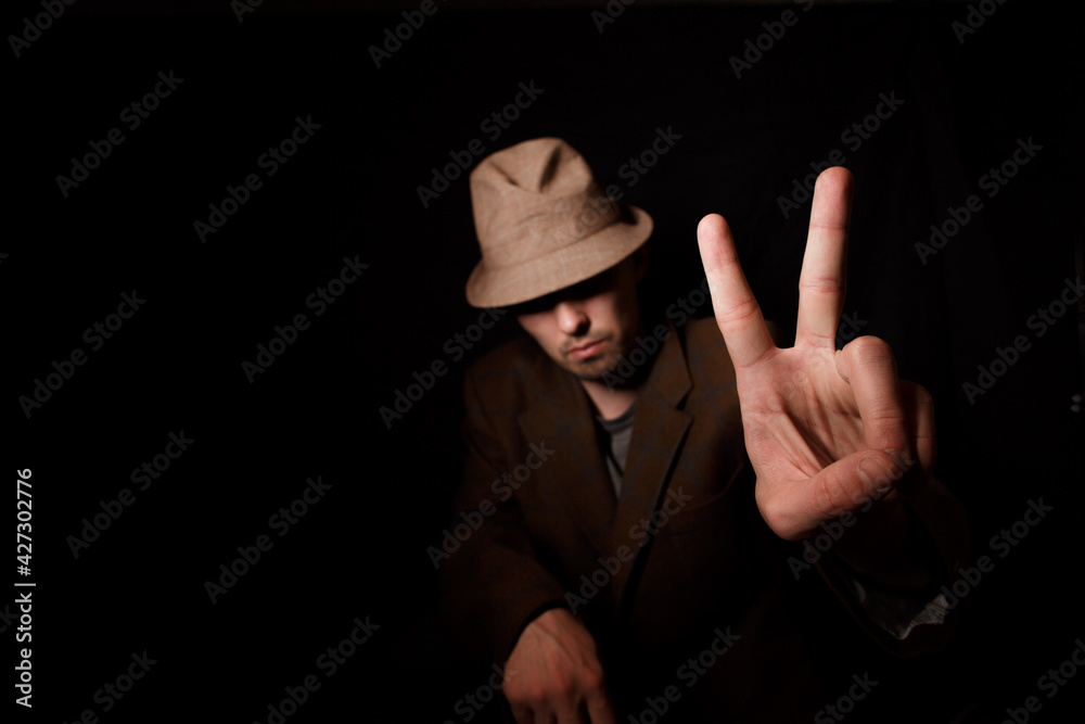 A man in the dark with a hat. A man in the dark with a hat.
