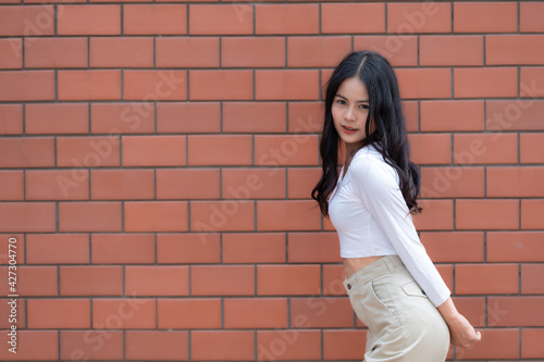 Portrait of hipster girl on brick wall background,Beautiful asian woman pose for take a photo,Kawaii style