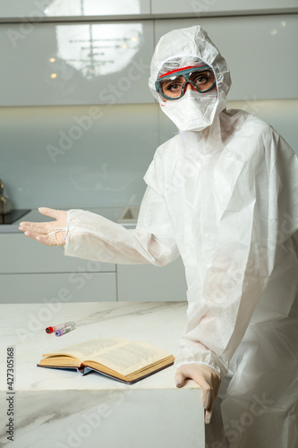 sick-nurse wearing covid protective Suit, FFP, gloves and protective glass reads a book photo