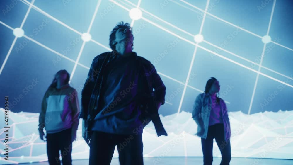 Diverse Group of Three Professional Dancers Performing a Hip Hop Dance Routine in Front of a Big Led Wall Screen with VFX Animation During a Virtual Production in Studio Environment. 105 BPM Song.